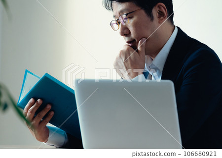Businessman worried about looking at documents 106680921