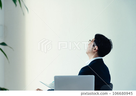 Businessman worried about looking at documents 106680945