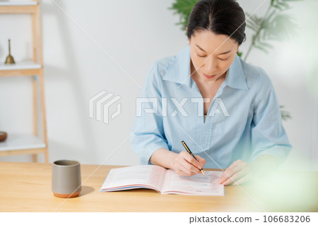Woman living room writing worried Woman living room writing worried 106683206
