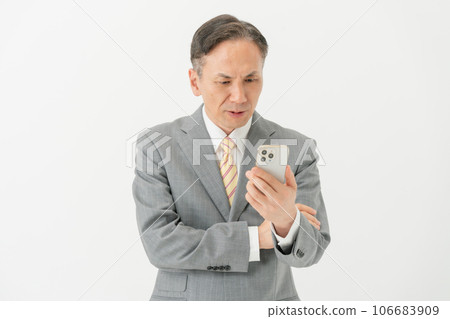 Business man who has trouble looking at his smartphone Business man who has trouble looking at his smartphone 106683909