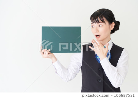 A woman in reception work and clerical work wearing a uniform with a ribbon tie on a vest with a blackboard A woman in reception work and clerical work wearing a uniform with a ribbon tie on a vest with a blackboard 106687551