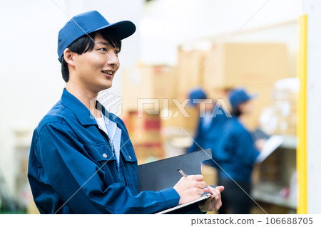 Young male and female workers wearing work clothes working in a warehouse 106688705