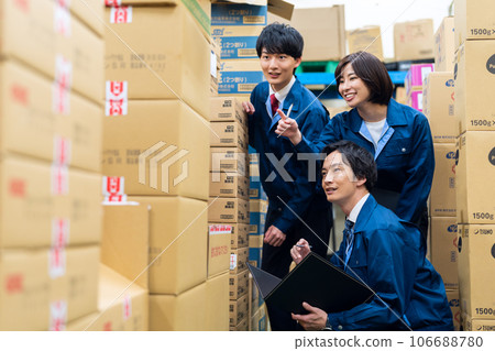 Young male and female businessmen wearing work clothes inspecting products in a warehouse at a distribution center Young male and female businessmen wearing work clothes inspecting products in a warehouse at a distribution center 106688780