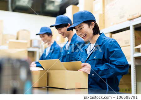 Young male and female workers packing luggage in a warehouse 106688791