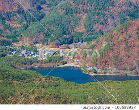 Aerial view of a lakeside village between a sea of trees and mountains with autumn leaves (Saiko, Yamanashi Prefecture) Aerial view of a lakeside village between a sea of trees and mountains with autumn leaves (Saiko, Yamanashi Prefecture) 106688957