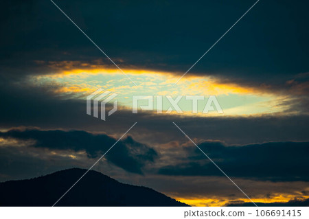 An oval sunny spot among the clouds in the evening An oval sunny spot among the clouds in the evening 106691415