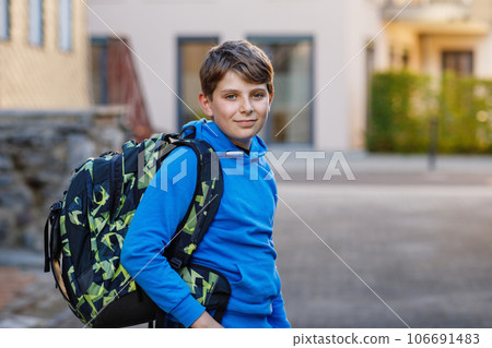 Happy preteen kid boy with satchel, walking. Schoolkid on the way to middle or high school. Excited child outdoors on school yard. Back to school. Happy preteen kid boy with satchel, walking. Schoolkid on the way to middle or high school. Excited child outdoors on school yard. Back to school. 106691483