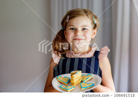 Happy little preschool girl celebrating birthday. Closeup of child with homemade biscuite cake, indoor. Happy healthy kid indoors Happy little preschool girl celebrating birthday. Closeup of child with homemade biscuite cake, indoor. Happy healthy kid indoors 106691518