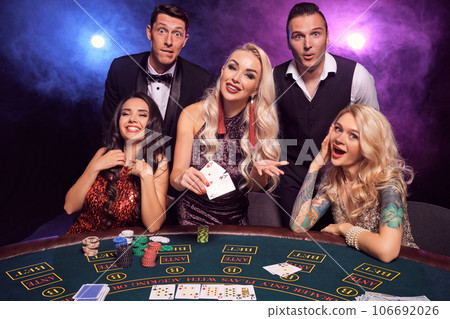 Group of a young wealthy friends are playing poker at a casino. Group of a young wealthy friends are playing poker at a casino. 106692026