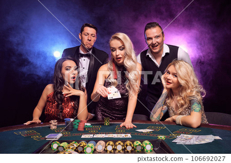 Group of a young wealthy friends are playing poker at a casino. Group of a young wealthy friends are playing poker at a casino. 106692027