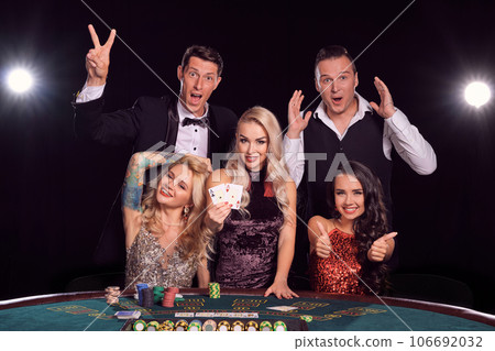 Group of a stylish rich friends are playing poker at casino. Group of a stylish rich friends are playing poker at casino. 106692032
