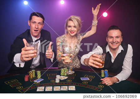 Group of a young wealthy friends are playing poker at a casino. Group of a young wealthy friends are playing poker at a casino. 106692069