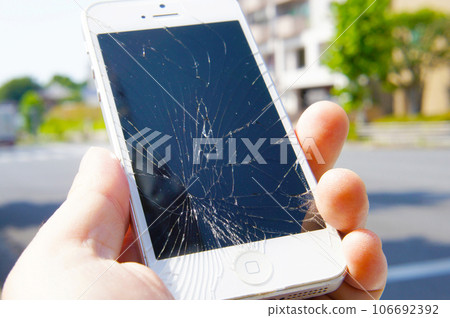 Smartphone with broken LCD screen after being dropped on the road 106692392