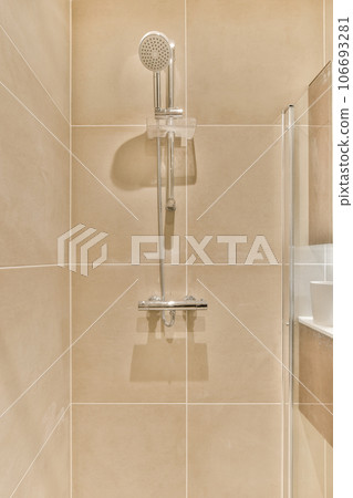 a bathroom with a shower head and hand held in front of the wall mounted fauced on the right side 106693281