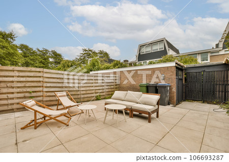 a patio with chairs and a fire pit in the middle of the yard, next to a fenced backyard area a patio with chairs and a fire pit in the middle of the yard, next to a fenced backyard area 106693287