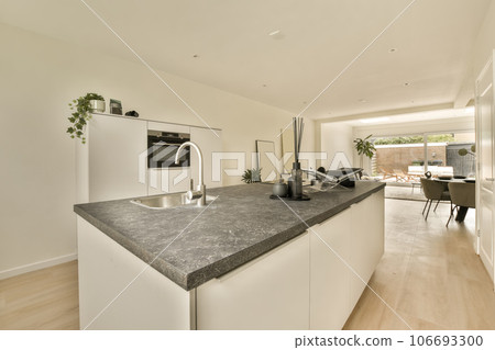 a modern kitchen with white cabinets and black granite counter tops in an open plan living room on the other side a modern kitchen with white cabinets and black granite counter tops in an open plan living room on the other side 106693300