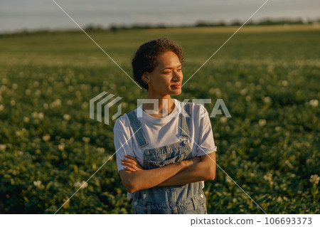 Female agronomist with crossed hands standing on potato field background. Agriculture concept Female agronomist with crossed hands standing on potato field background. Agriculture concept 106693373