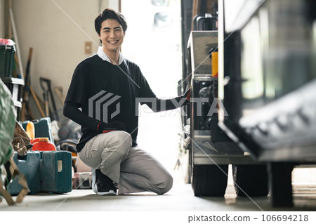 A worker inspecting truck tires 106694218