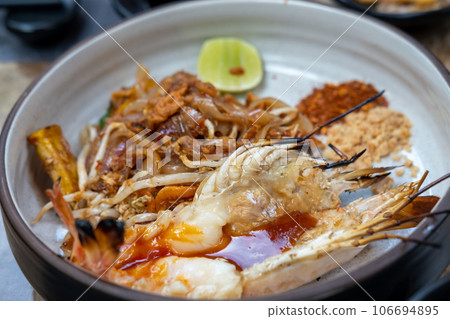 Pad Thai with river prawn serve on plate. It is a stir-fried rice noodle thai dish 106694895