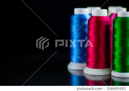 set of different color sewing threads,on black background. 106695983