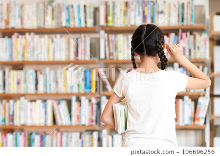 A girl choosing a book 106696256