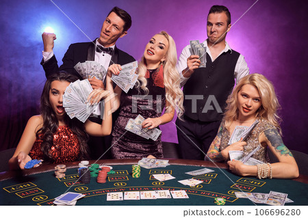 Group of a young wealthy friends are playing poker at a casino. Group of a young wealthy friends are playing poker at a casino. 106696280