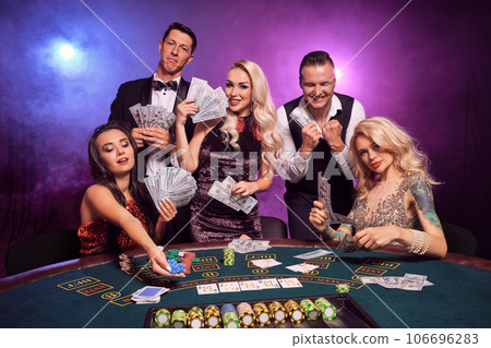 Group of a young wealthy friends are playing poker at a casino. 106696283