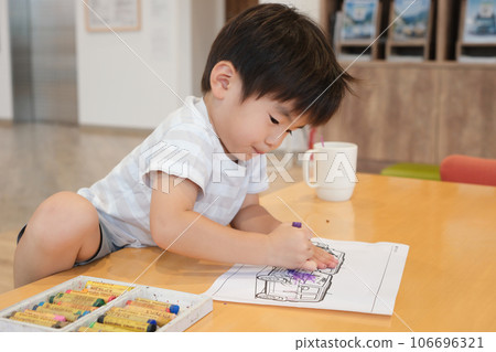 boy playing with coloring book boy playing with coloring book 106696321