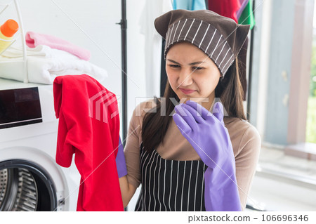Asian young woman dissatisfied smell of cloth after laundry Asian young woman dissatisfied smell of cloth after laundry 106696346