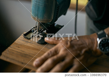 Carpenter using a circular saw 106696370