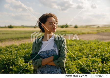 Woman agronomist with crossed hands standing on potato field background. Agriculture concept 106696396