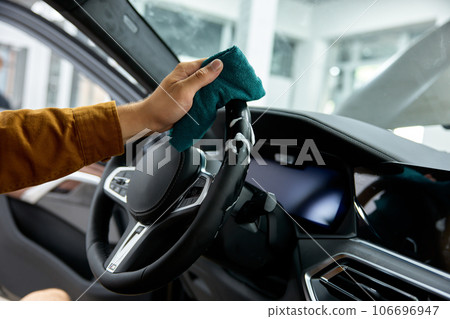 Male hands washing steering wheel with rag, car interior dry cleansing 106696947