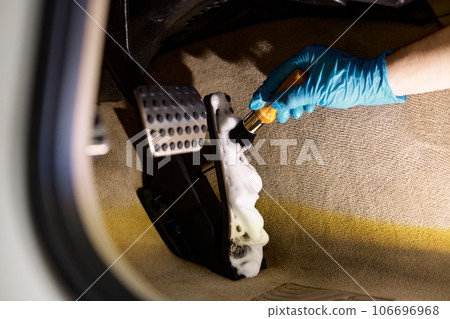 Car detailing procedure, closeup worker hand with brush cleaning pedals 106696968