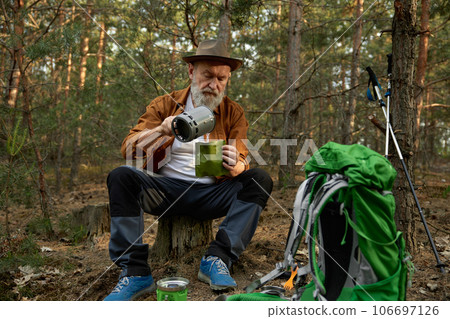 Senior man traveler using portable gas burner to cook dinner Senior man traveler using portable gas burner to cook dinner 106697126