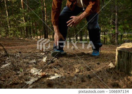 Senior man sprained leg during hiking trip outdoors in forest Senior man sprained leg during hiking trip outdoors in forest 106697134