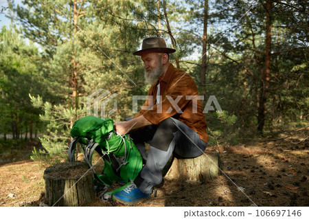Cheerful senior male traveler preparing for rest after hiking 106697146