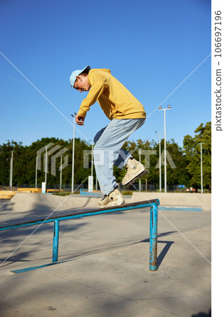 Talented teen guy roller skating making trick on border 106697196