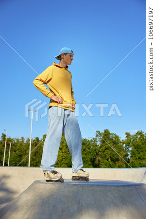 Serious sportsman wearing roller blades preparing for fast riding on ramp 106697197