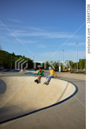 Active positive teenager friends rest after good training in rollerdrom 106697206