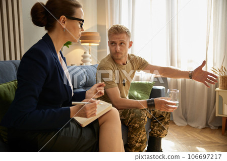 Woman psychotherapist working with male military officer in office 106697217