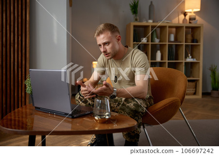 Military man holding online consultation with psychiatrist sitting at home Military man holding online consultation with psychiatrist sitting at home 106697242