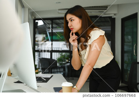 Focused millennial businesswoman looking at computer monitor and thinking, solving problem or review project Focused millennial businesswoman looking at computer monitor and thinking, solving problem or review project 106697668