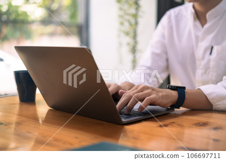 Young businessman in white shirt typing on laptop, searching information or working online Young businessman in white shirt typing on laptop, searching information or working online 106697711