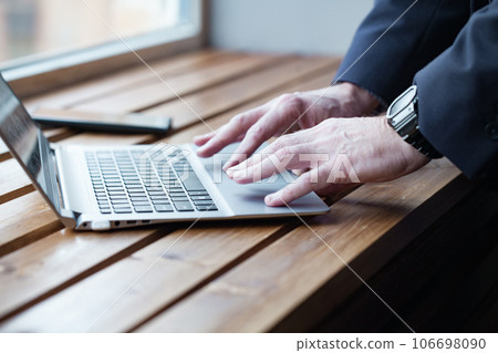 Businessman hands with watch working on laptop, fingers typing on the keyboard. Close up 106698090