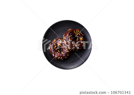 Pastries concept. Donuts with chocolate glaze with sprinkles, on a dark concrete table 106701341