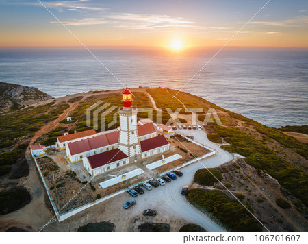 Aerial drone view of lighthouse on Cabo Espichel cape Espichel on Atlantic ocean at sunset. Sesimbra, Portugal 106701607