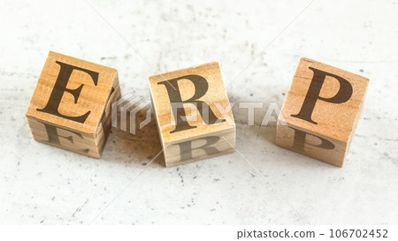 Three wooden cubes with letters ERP - stands for Enterprise Resource Planning - on white board. 106702452