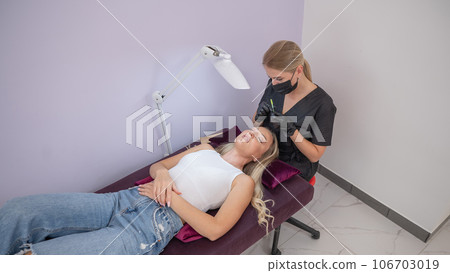 Caucasian woman on eyelash extension procedure. Caucasian woman on eyelash extension procedure. 106703019