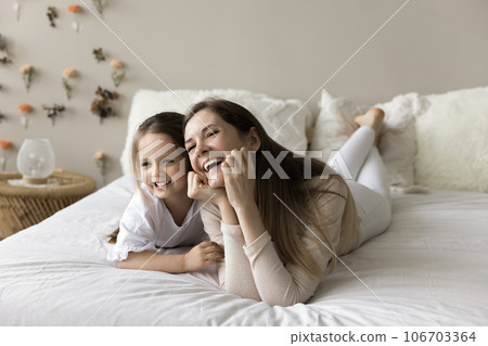 Cheerful loving mother and little toddler kid relaxing on bed Cheerful loving mother and little toddler kid relaxing on bed 106703364