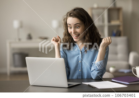 Cheerful winner girl celebrating victory at laptop, enjoying business achievement Cheerful winner girl celebrating victory at laptop, enjoying business achievement 106703401